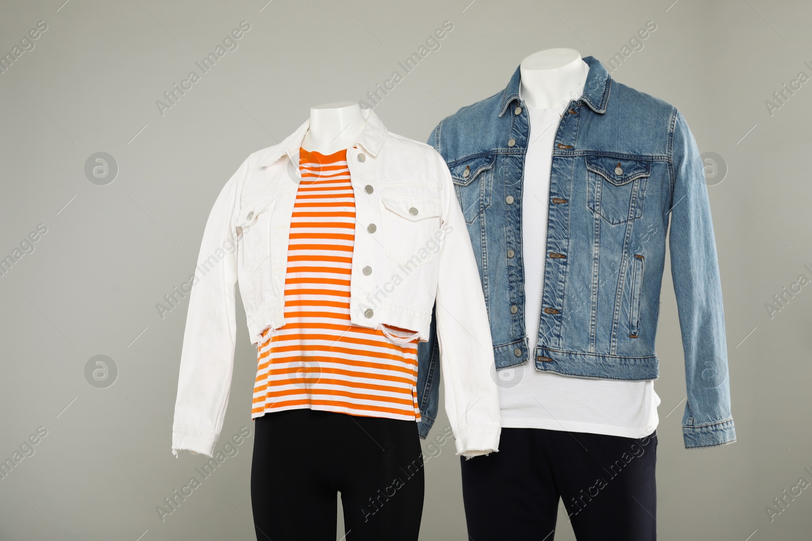 Photo of Female and male mannequins with stylish outfits on light grey background