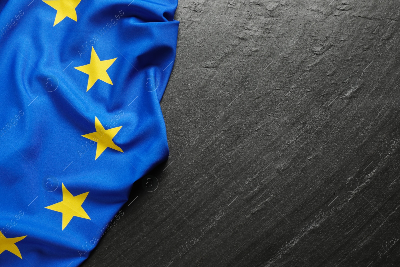 Photo of Flag of European Union on black textured background, top view. Space for text