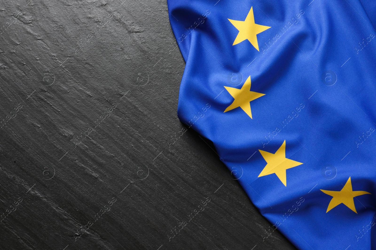 Photo of Flag of European Union on black textured background, top view. Space for text