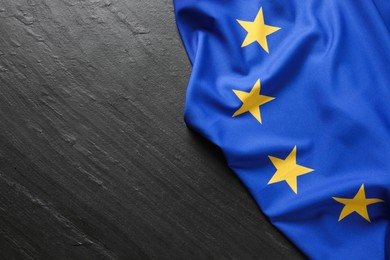 Photo of Flag of European Union on black textured background, top view. Space for text