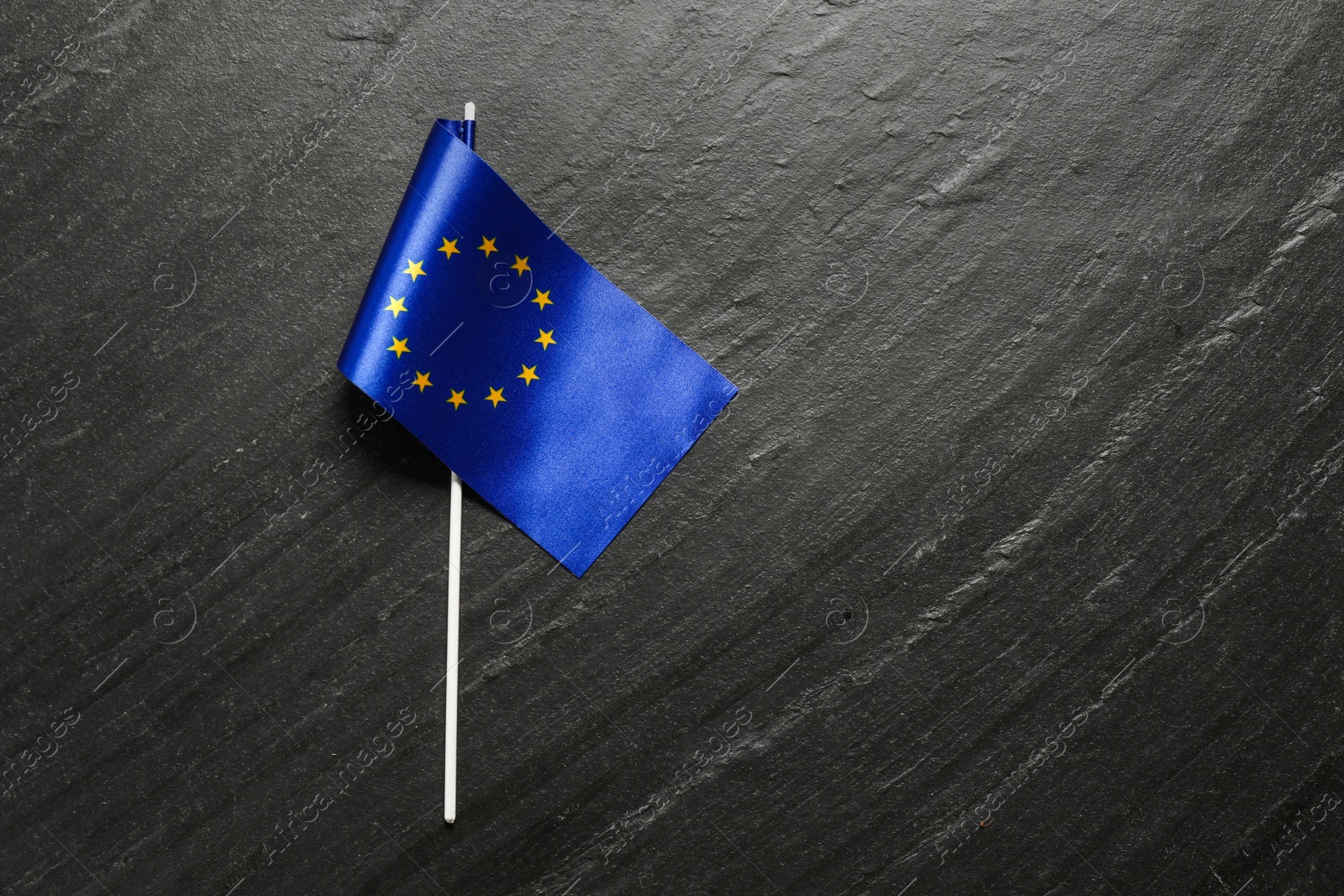 Photo of Flag of European Union on black textured background, top view. Space for text