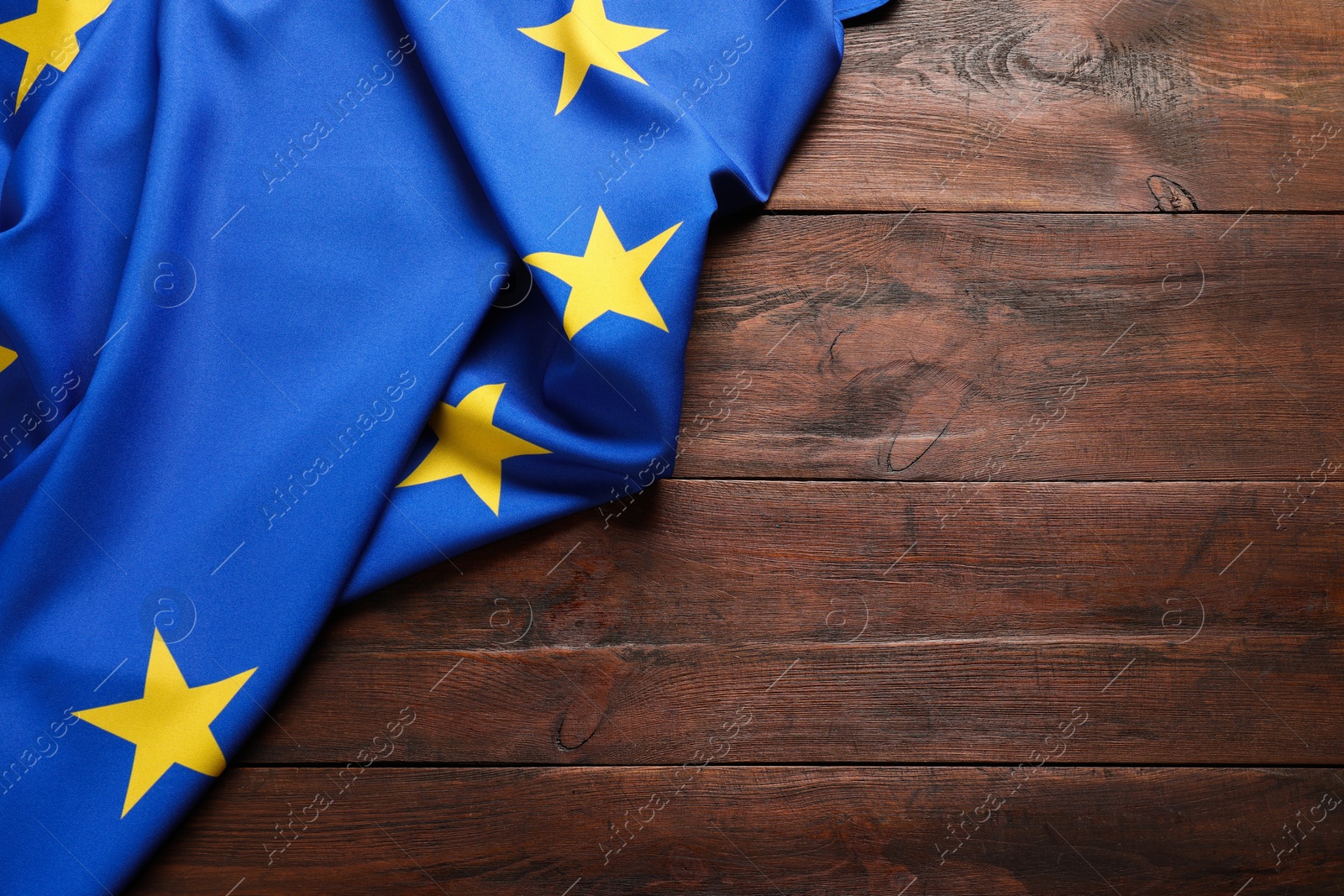 Photo of Flag of European Union on wooden background, top view. Space for text