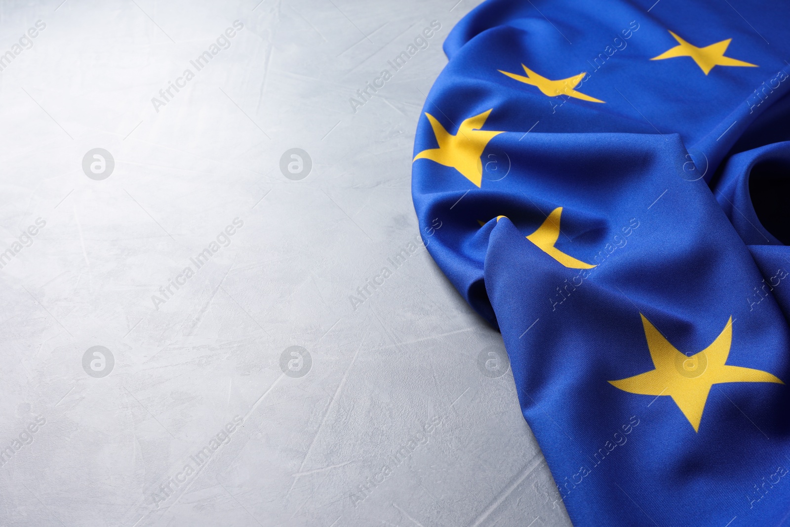 Photo of Flag of European Union on light grey table, space for text