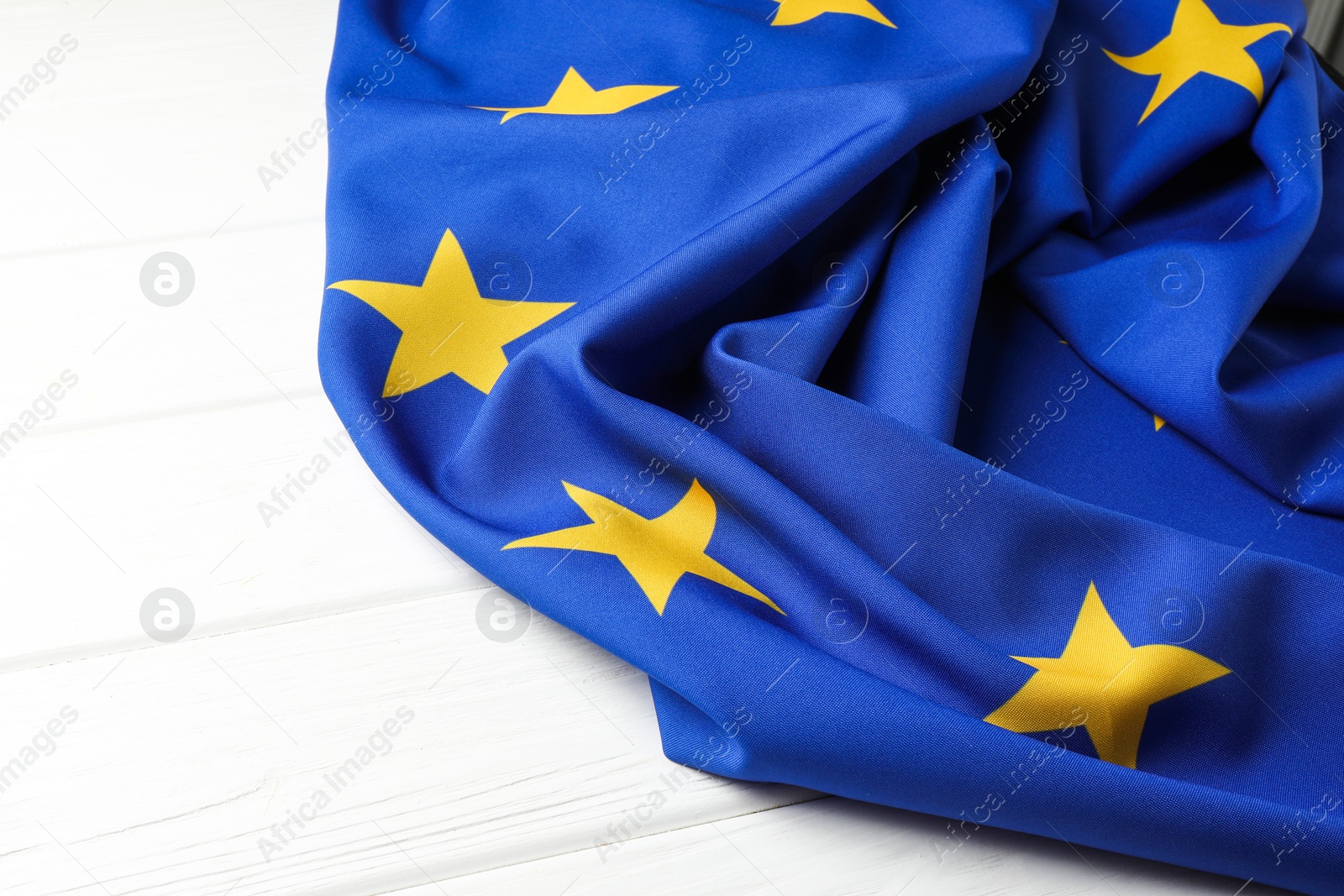 Photo of Flag of European Union on white wooden table, closeup