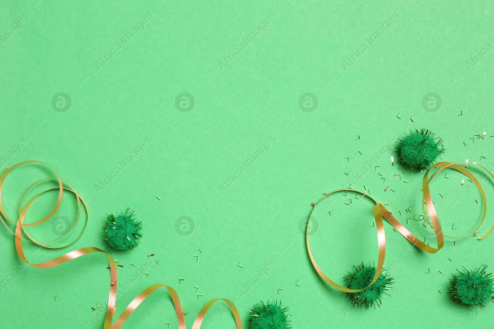 Photo of Festive composition with shiny confetti and party decor on green background, flat lay. Space for text