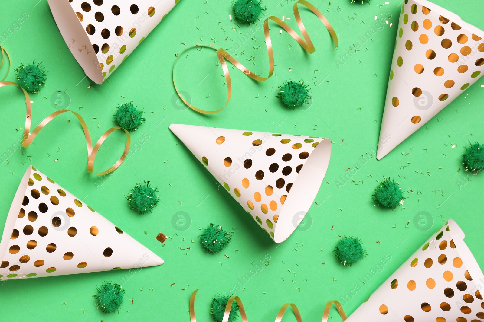 Photo of Festive composition with shiny confetti and party decor on green background, flat lay