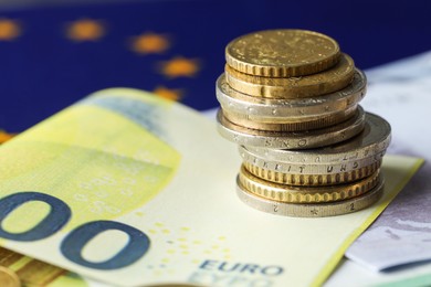 Photo of Euro banknotes and coins on European Union flag, closeup