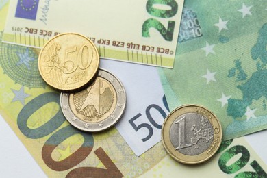 Photo of Different coins on euro banknotes, top view