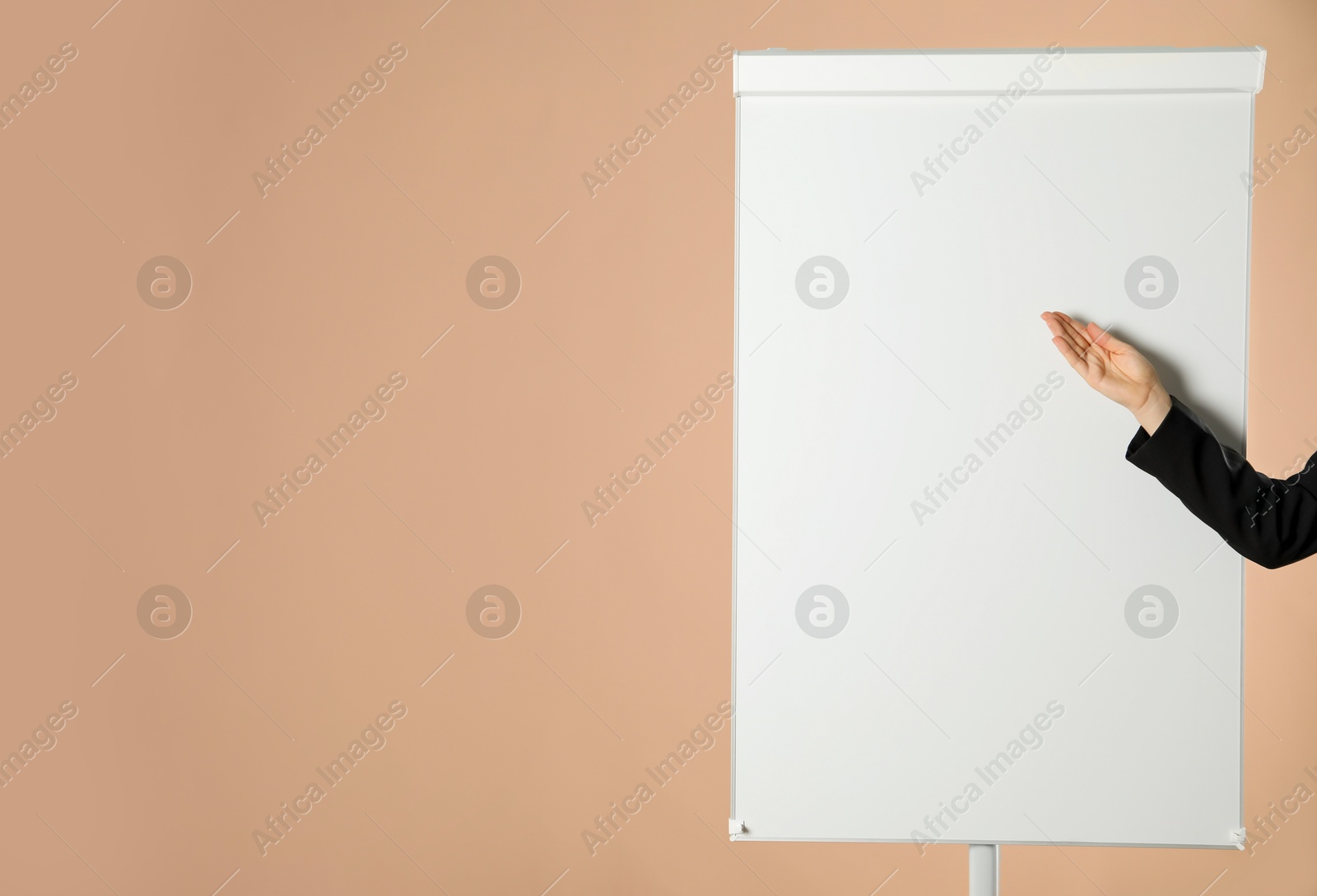 Photo of Woman near flip chart on pale brown background, closeup. Mockup for design