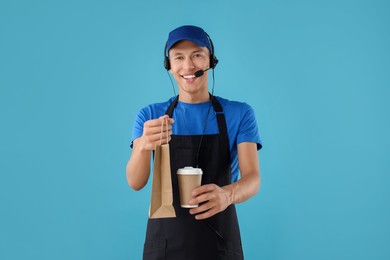 Photo of Fast-food worker with paper bag and cup on light blue background