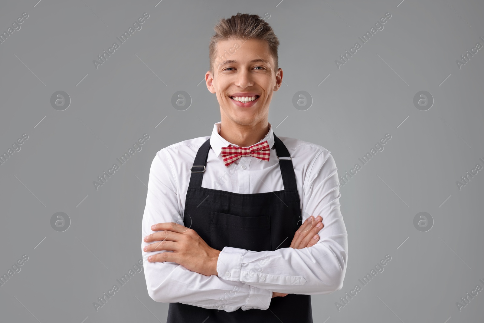 Photo of Portrait of smiling fast-food worker on gray background