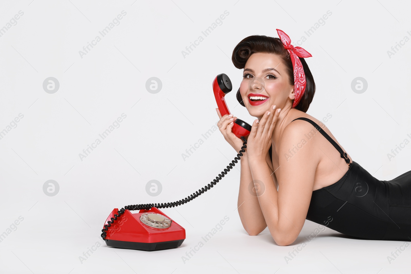 Photo of Pin-up woman with telephone on light background