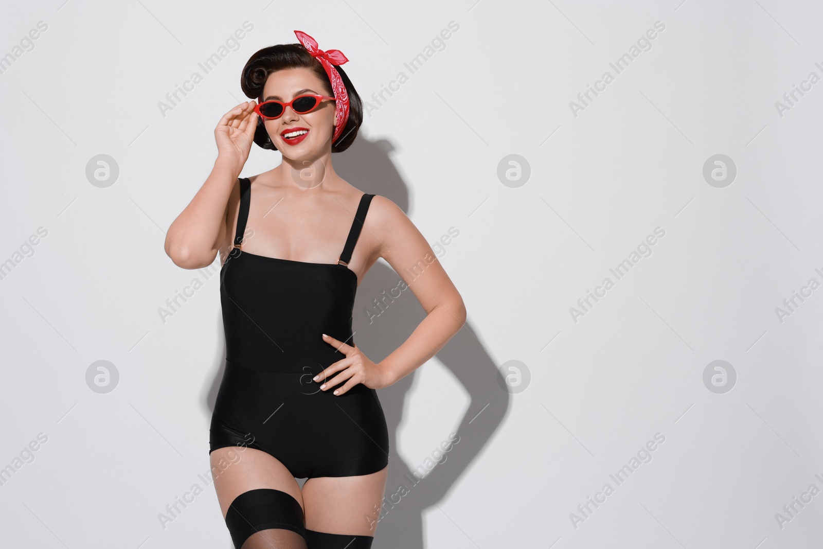 Photo of Portrait of pin-up woman on light background, space for text