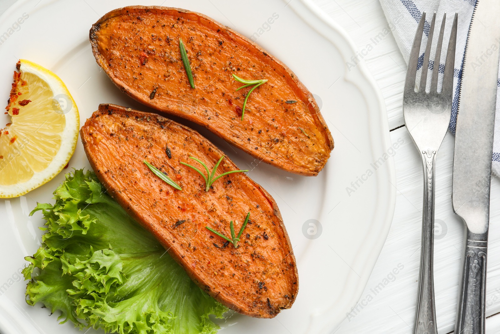 Photo of Tasty baked sweet potato served on white wooden table, flat lay