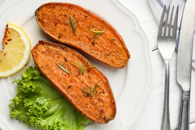 Tasty baked sweet potato served on white wooden table, flat lay