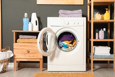 Photo of Washing machine, detergents and towels in room