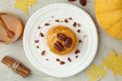 Photo of Tasty pumpkin pancakes with nuts and honey served on light grey table, flat lay