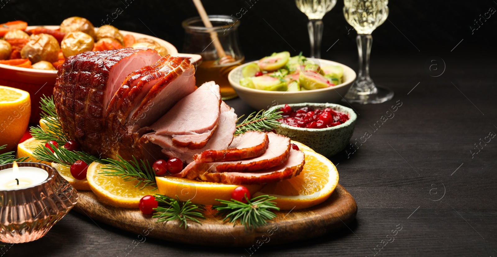 Photo of Tasty baked ham served on black wooden table