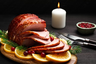 Photo of Tasty baked ham served on black wooden table