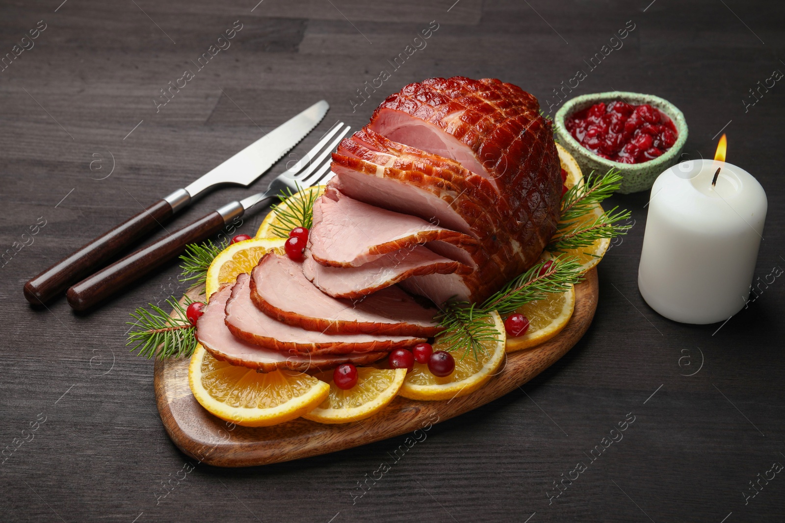 Photo of Tasty baked ham served on black wooden table