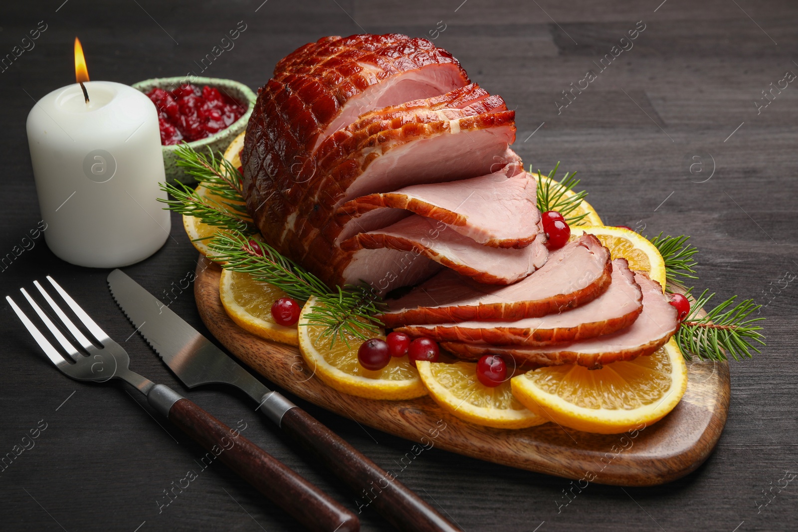 Photo of Tasty baked ham served on black wooden table