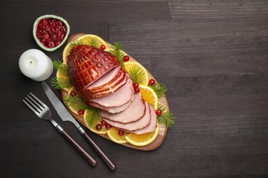 Photo of Tasty baked ham served on black wooden table, flat lay. Space for text