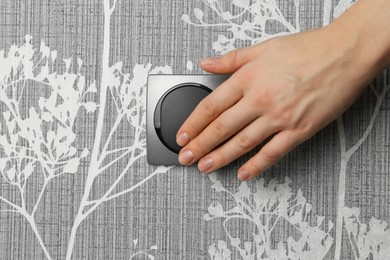 Photo of Woman turning light switch on, closeup view