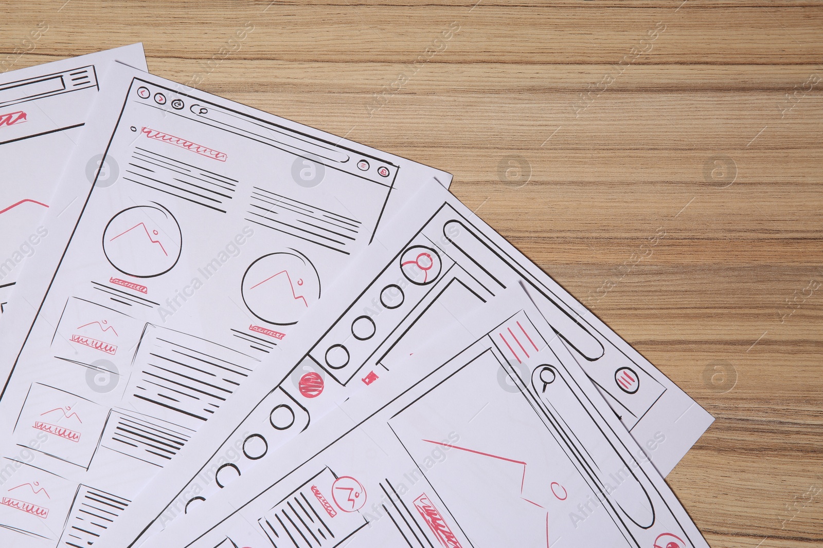 Photo of Website development. Sketches of wireframes on wooden table, flat lay