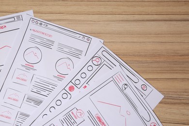 Photo of Website development. Sketches of wireframes on wooden table, flat lay