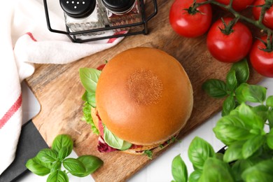 Photo of Delicious vegan burger with chickpea cutlet on white tiled table