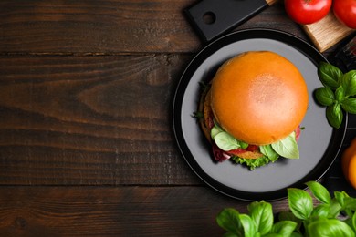 Photo of Delicious vegan burger with chickpea cutlet on wooden table, flat lay. Space for text