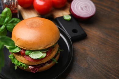 Photo of Delicious vegan burger with chickpea cutlet on wooden table, closeup. Space for text