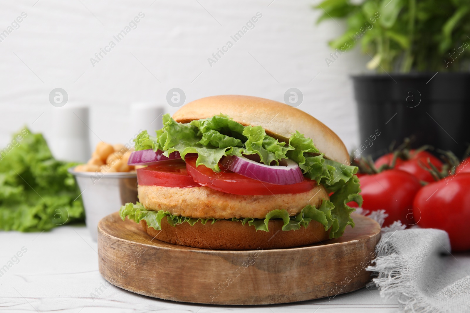 Photo of Delicious vegetarian burger with chickpea cutlet on white table, closeup