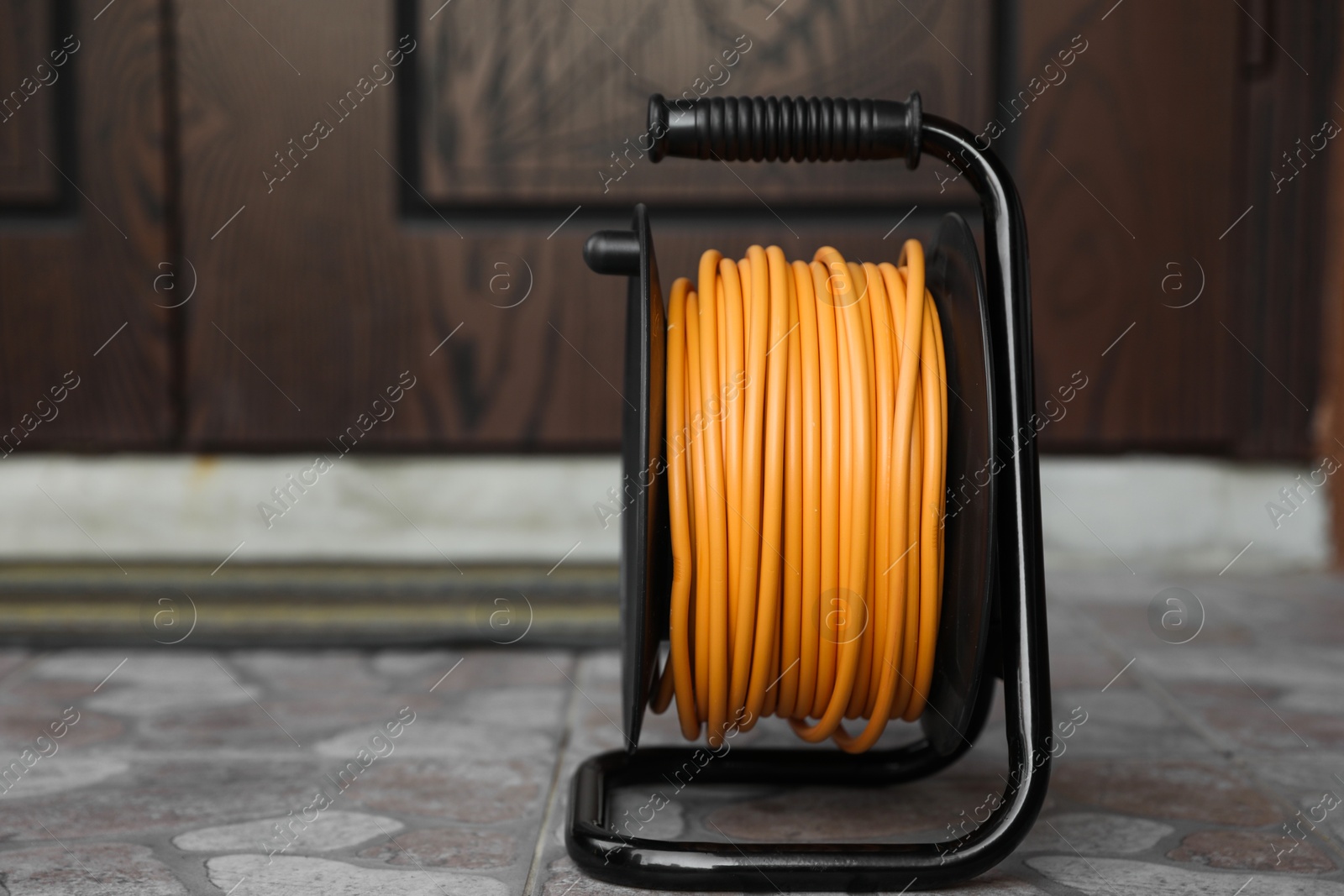 Photo of One extension cord reel on pavement outdoors