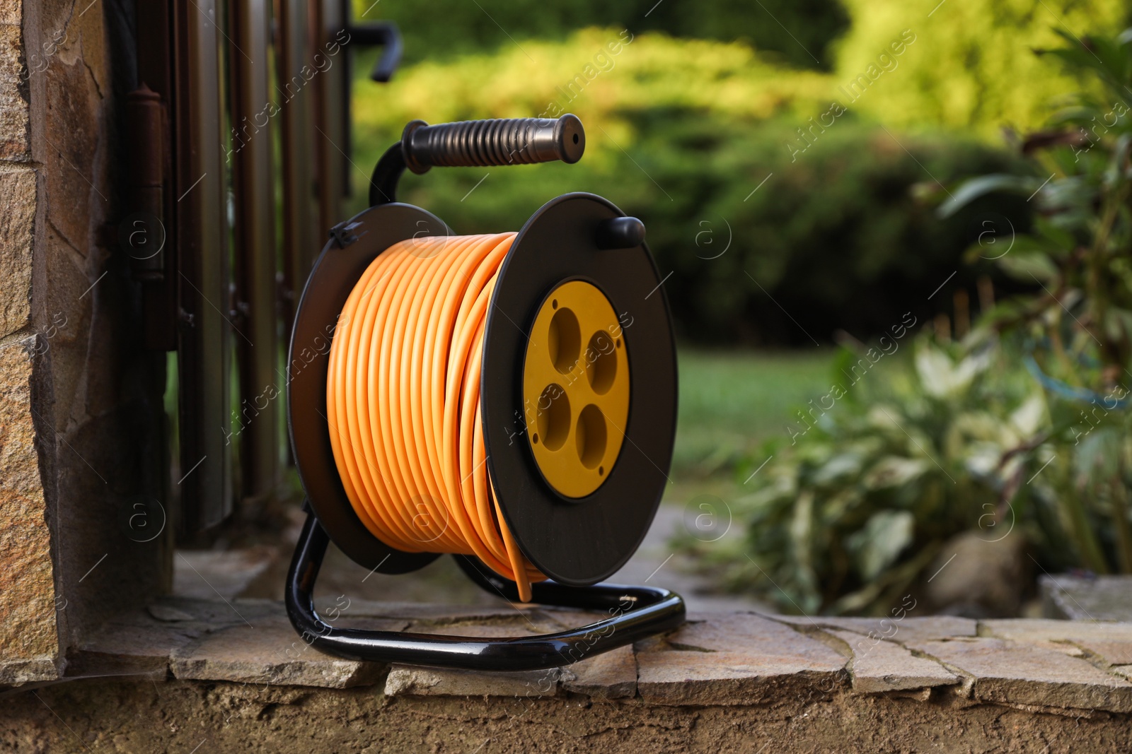 Photo of One extension cord reel outdoors, space for text