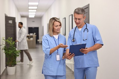 Photo of Healthcare workers with clipboard talking in hospital