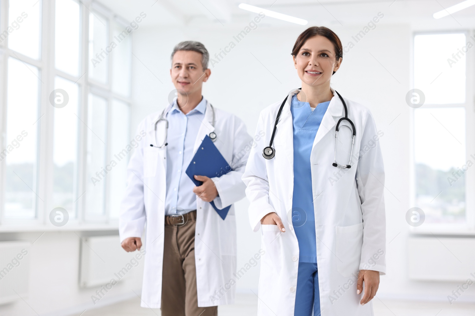 Photo of Healthcare workers with stethoscope and clipboard in hospital, selective focus