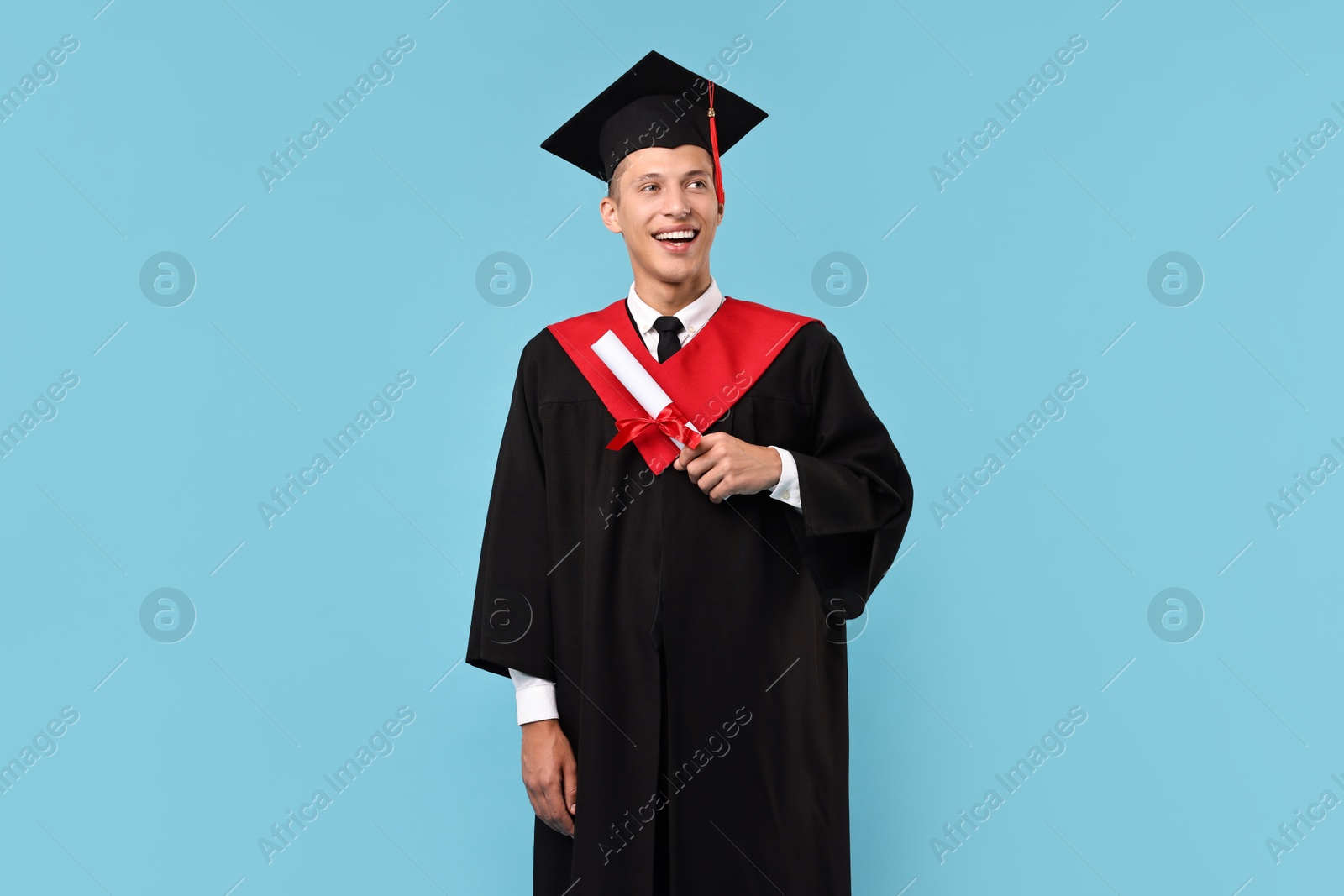 Photo of Happy student with diploma after graduation on light blue background