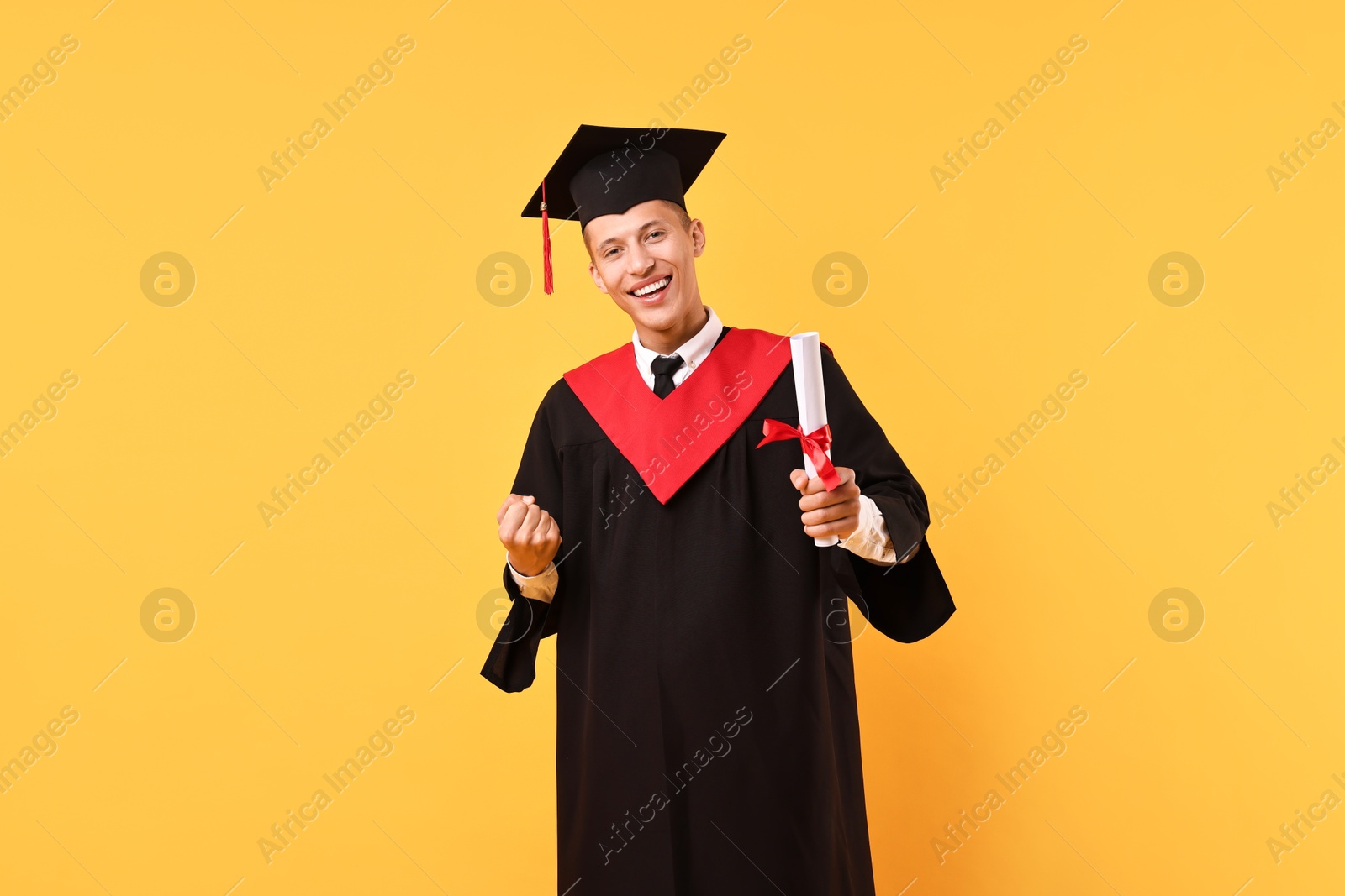 Photo of Happy student with diploma after graduation on orange background