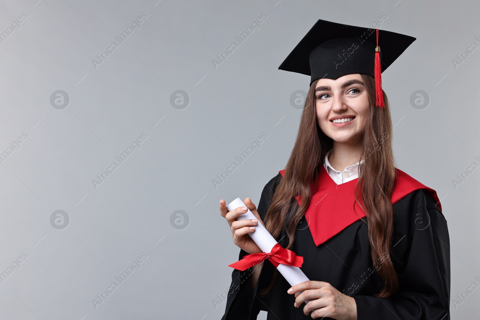 Photo of Happy student with diploma after graduation on grey background. Space for text