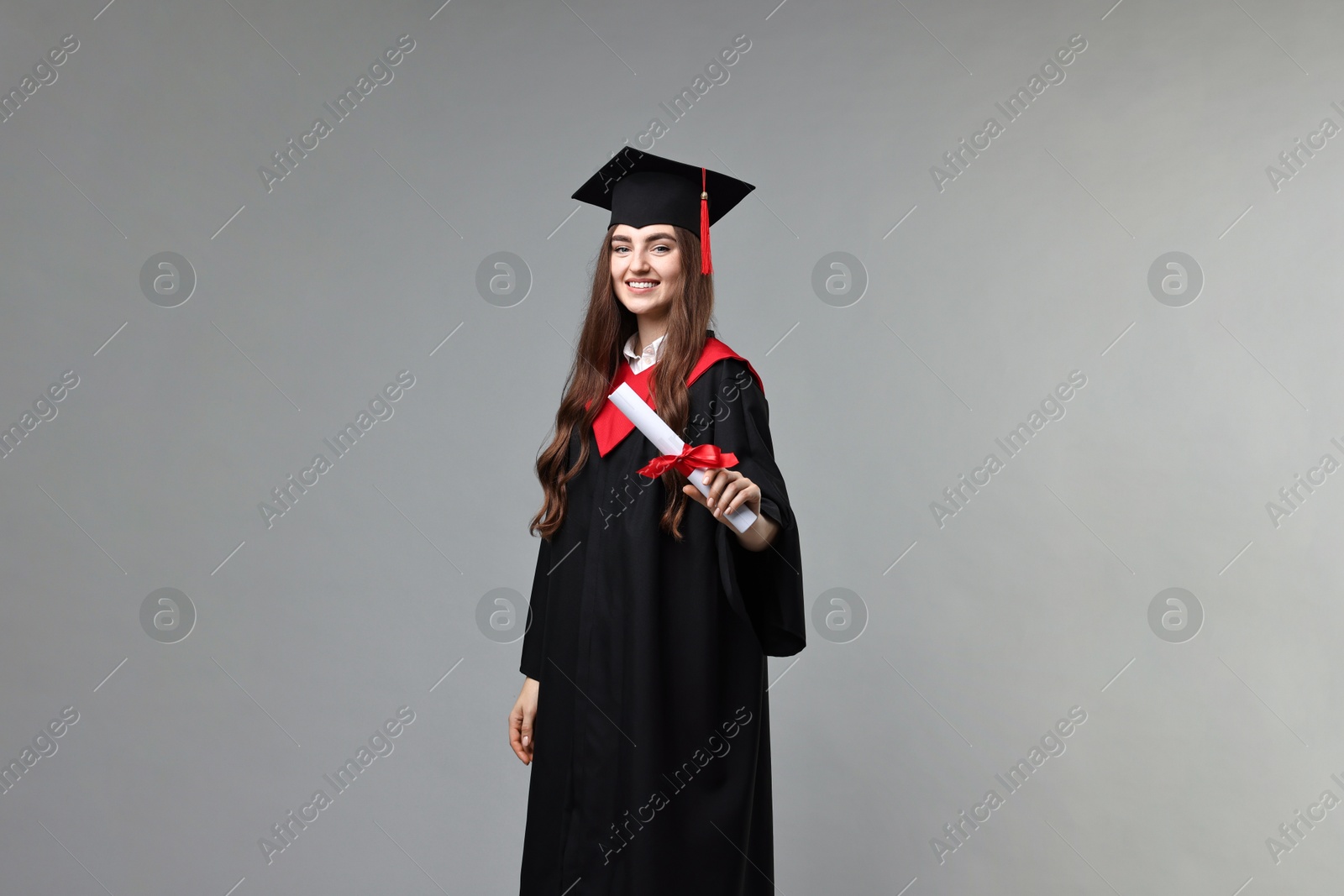 Photo of Happy student with diploma after graduation on grey background