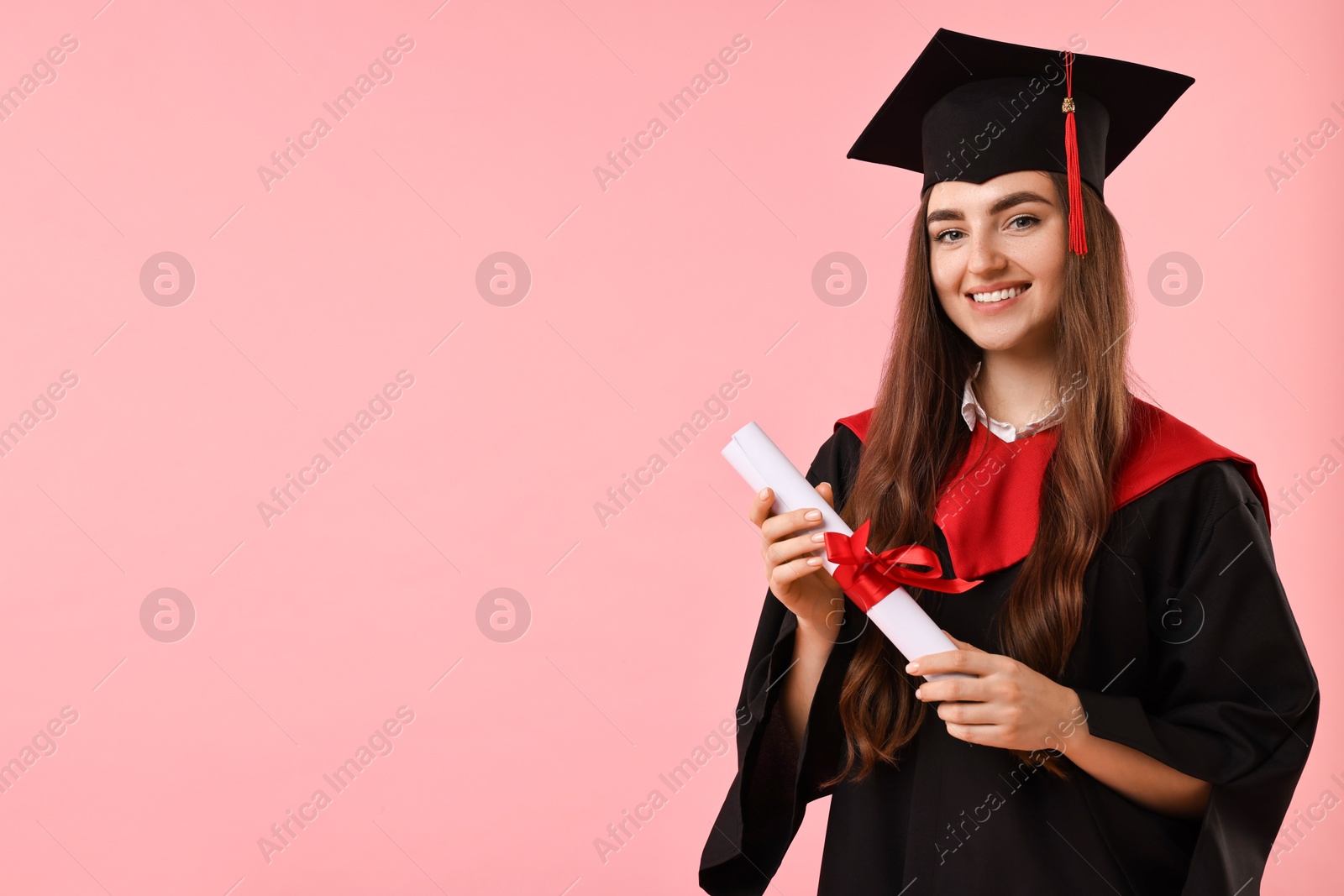 Photo of Happy student with diploma after graduation on pink background. Space for text