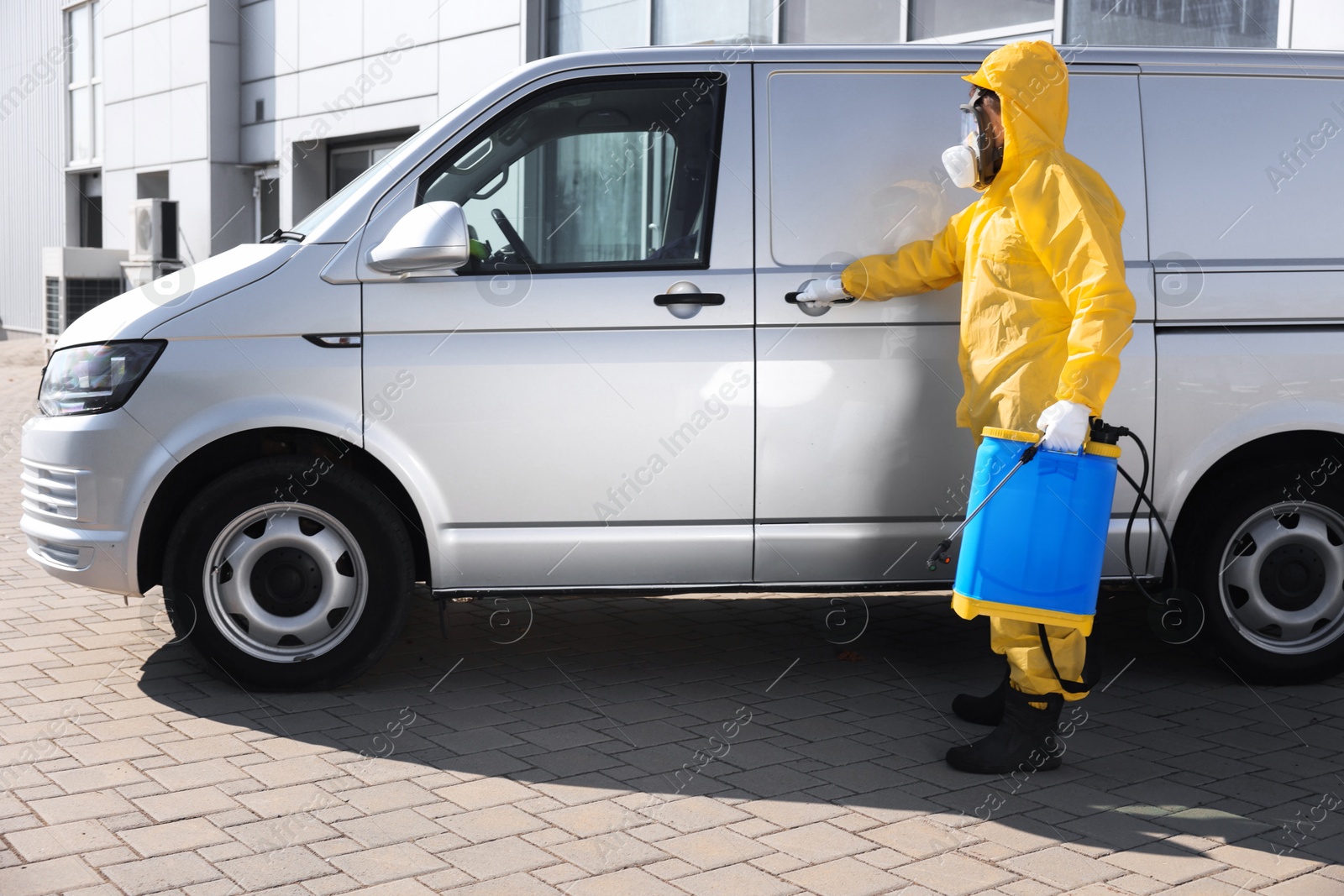 Photo of Pest control worker with spray tank near gray minibus outdoors