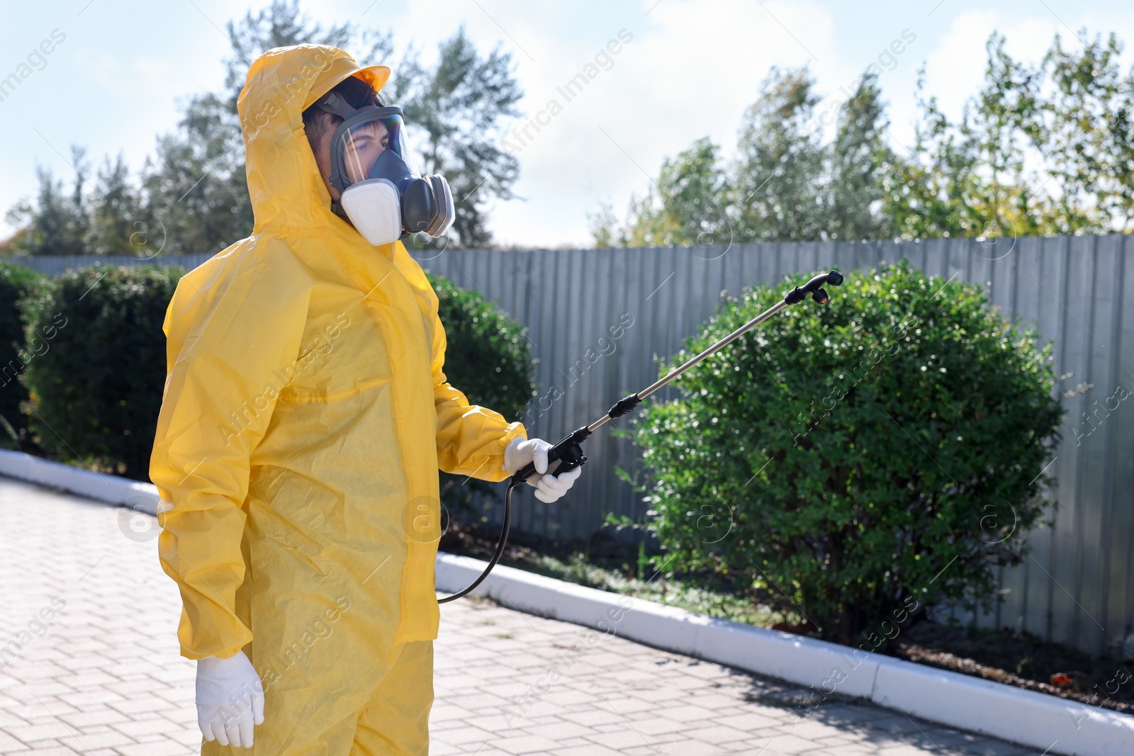 Photo of Pest control worker with spray tank outdoors