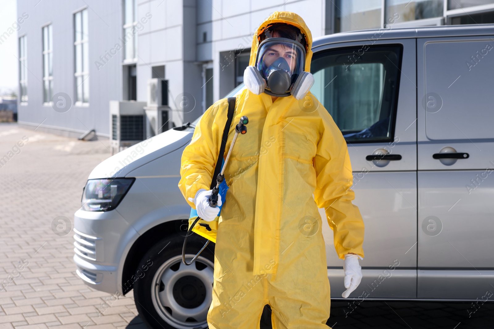 Photo of Pest control worker with spray tank outdoors