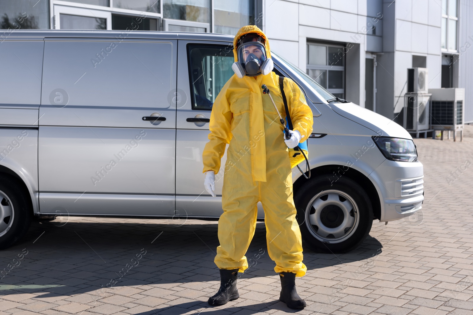 Photo of Pest control worker with spray tank outdoors