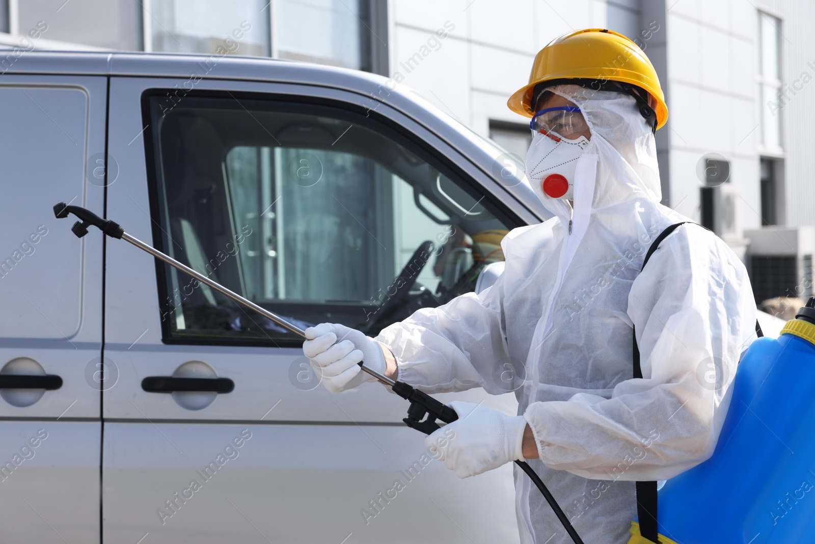 Photo of Pest control worker with spray tank near gray minibus outdoors