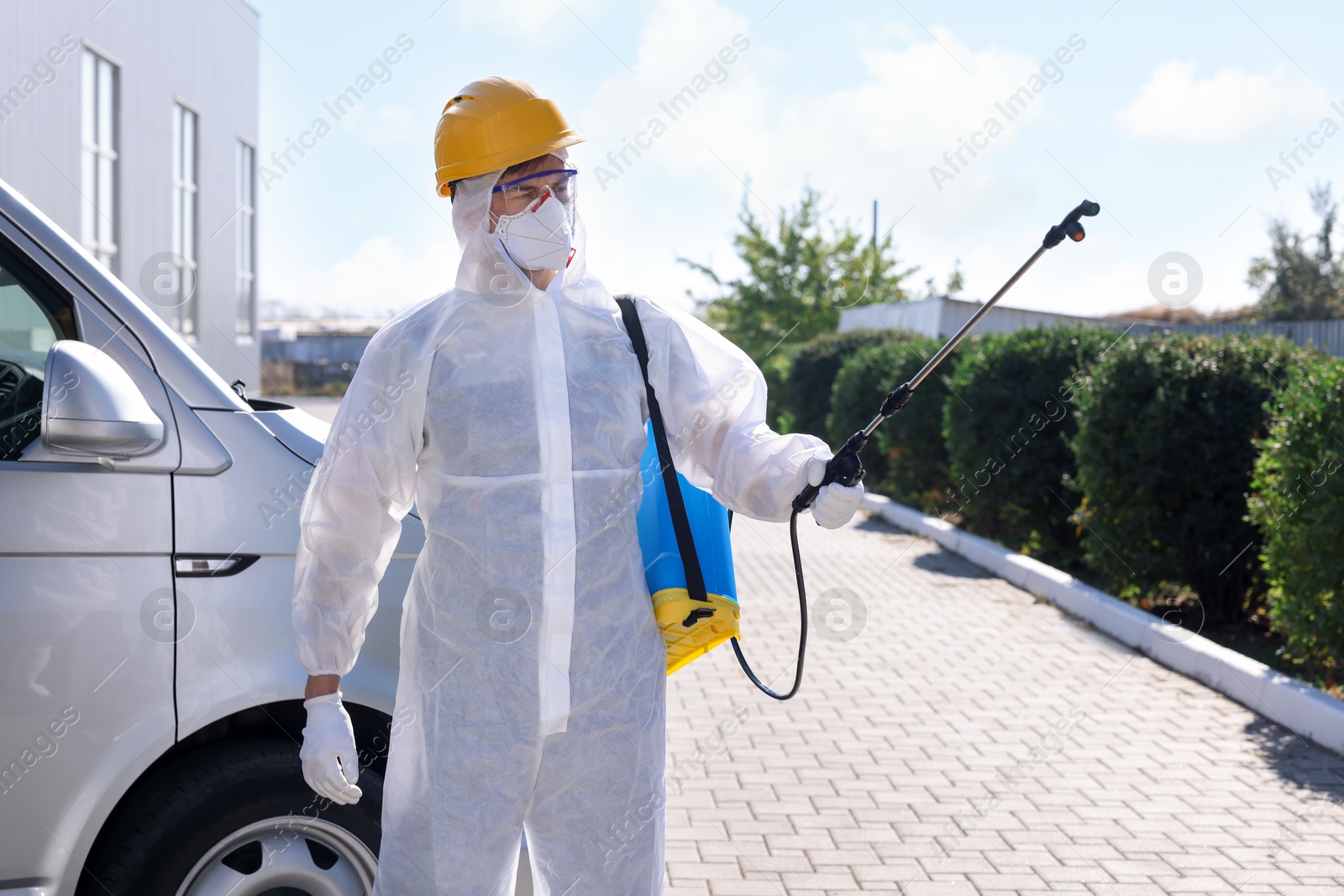 Photo of Pest control worker with spray tank outdoors