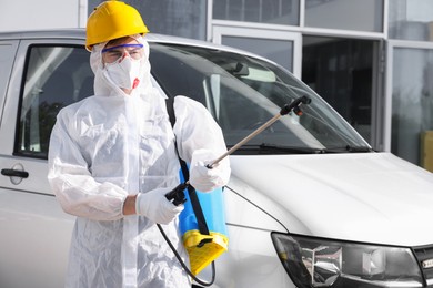 Photo of Pest control worker with spray tank near gray minibus outdoors