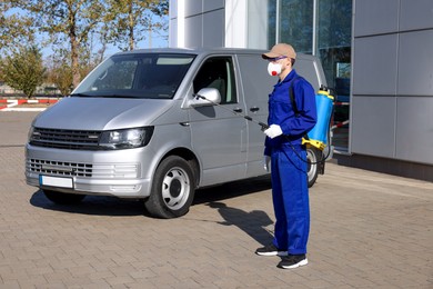 Photo of Pest control worker with spray tank outdoors